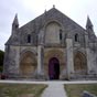 Façade Ouest : L'étage inférieur de la façade contraste fortement avec la nudité de la partie haute. Un portail à quatre larges voussures occupe toute la partie centrale. Il est flanqué de chaque côté de deux baies aveugles en arc brisé, dotées de trois v