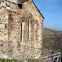 Recouverte de lauzes, l'église est percée de trois fenêtres ogivales.