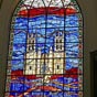 Intérieur de l'église Saint-Roch : Ce vitrail contemporain (maître-autel) installé vers 1980 représente saint Roch cheminant avec son chien vers la cathédrale de Montpellier.