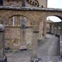 On pense à une chapelle templière ou à un sanctuaire funéraire (lanterne des morts). Les arcades qui entourent la construction sont aussi une énigme. 