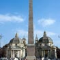 L'obélisque, au centre, date de l'époque de Ramsès II et a été rapporté d'Egypte par l'empereur Auguste pour orner le grand cirque Maximus. Il a été une dernière fois déplacé au centre de la place au XVIe siècle par le Pape Sixte V qui utilisait les obélisques pour guider les pèlerins vers Saint-Pierre. Les églises jumelles Santa-Maria-di-Montesanto et Santa-Maria-dei-miraculi qui encadrent l'entrée du Corso, ont été conçues par l'architecte Carlo Rainaldi comme un fond pour l'obélisque.