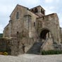 On aborde l'église par une petite place où, jadis s'élevait un cimetière. On est tout de suite séduit. On l'est toujours par un chevet roman: l'harmonie et la justesse des proportions y sont de règle. Mais il y a plus, à Auzon: une note personnelle, due, entre autres, à la magnifique patine de la pierre, d'un blond rosé; aux belles proportions de l'arcature du choeur et aussi à l'originalité du porche accolé au flanc sud. Malgré leur diversité, les masses qui composent l'édifice s'harmonisent bien: la sévérité du massif qui soutient le clocher faisant ressortir l'élégance du chevet à pans coupés et le décrochement de la "ganivelle" - c'est le nom que porte dans le pays le porche sud - y ajoutant une note d'imprévu.